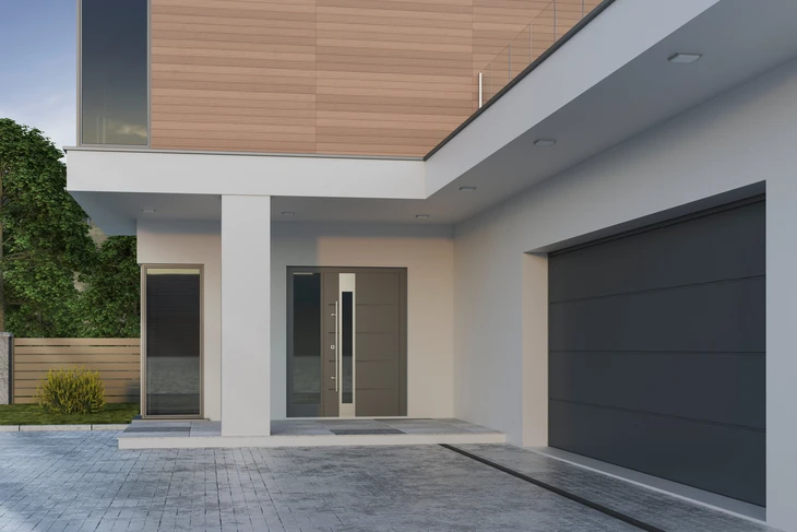 Scène d'intérieur professionnel avec deux personnes en costume échangeant une maquette de maison miniature au-dessus de documents contractuels