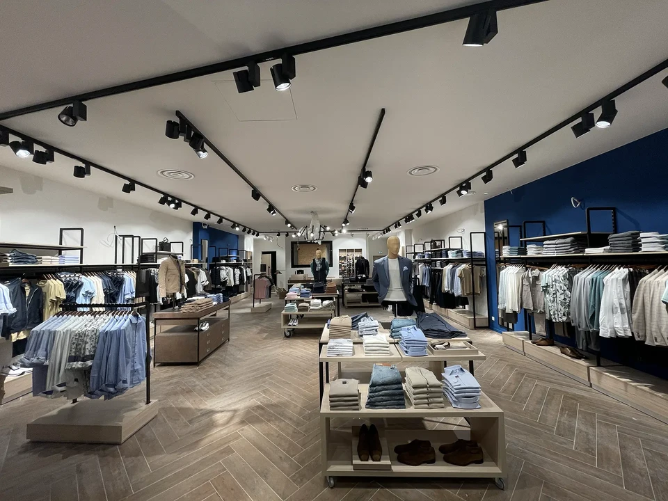 Magasin de meubles moderne avec canapés gris disposés dans un showroom spacieux