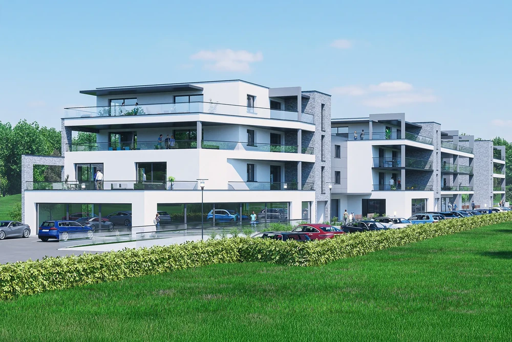 Complexe résidentiel moderne à plusieurs niveaux avec balcons et terrasses, situé dans un environnement verdoyant avec pelouse et végétation naturelle