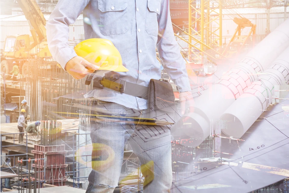 Scène d'intérieur professionnel avec deux personnes en costume échangeant une maquette de maison miniature au-dessus de documents contractuels