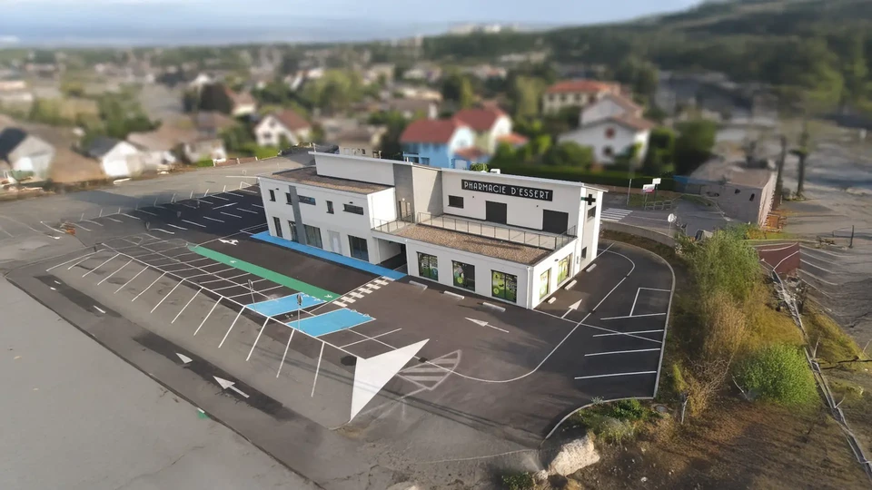 Complexe résidentiel moderne à plusieurs niveaux avec balcons et terrasses, situé dans un environnement verdoyant avec pelouse et végétation naturelle